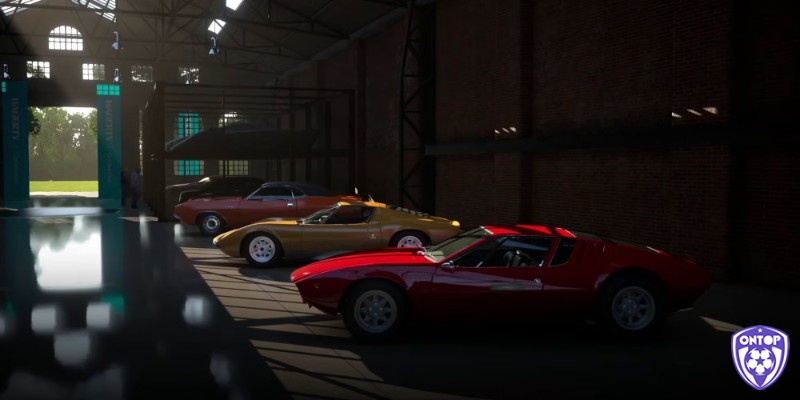 Cảnh gara với nhiều mẫu xe cổ điển và xe đua hiện đại được trưng bày theo bộ sưu tập